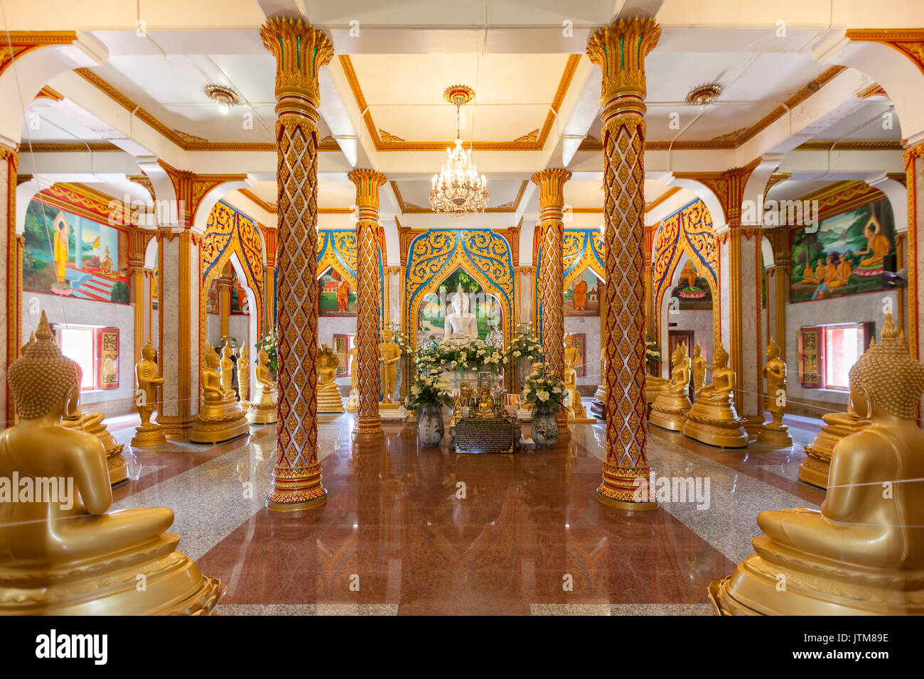 Gilded standing, seated and reclining Buddha statues inside the Viharn hall at Wat Chalong Temple in Phuket, Thailand Stock Photo