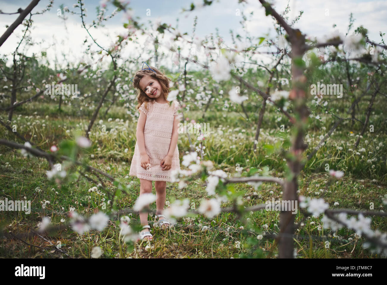 beautiful little girl in blooming garden Stock Photo - Alamy