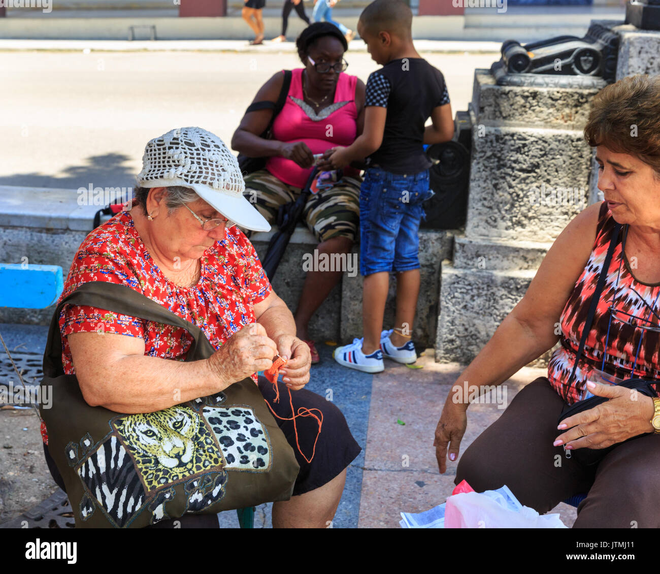 Elderly Cuban woman doing  needlework at a Sunday craft market on Pasel del Prado, Havana, Cuba Stock Photo