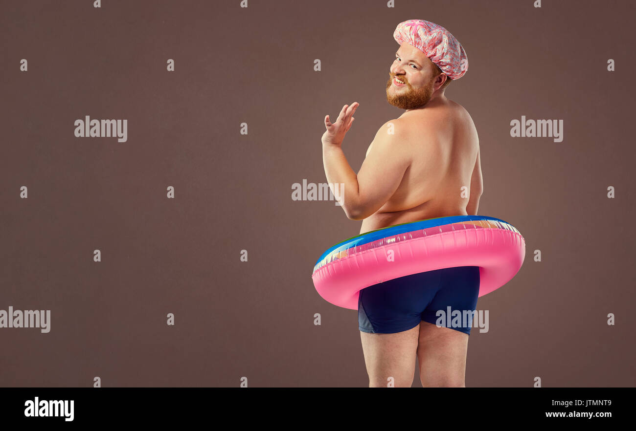 Fat funny man in a swimsuit with an inflatable circle Stock Photo - Alamy