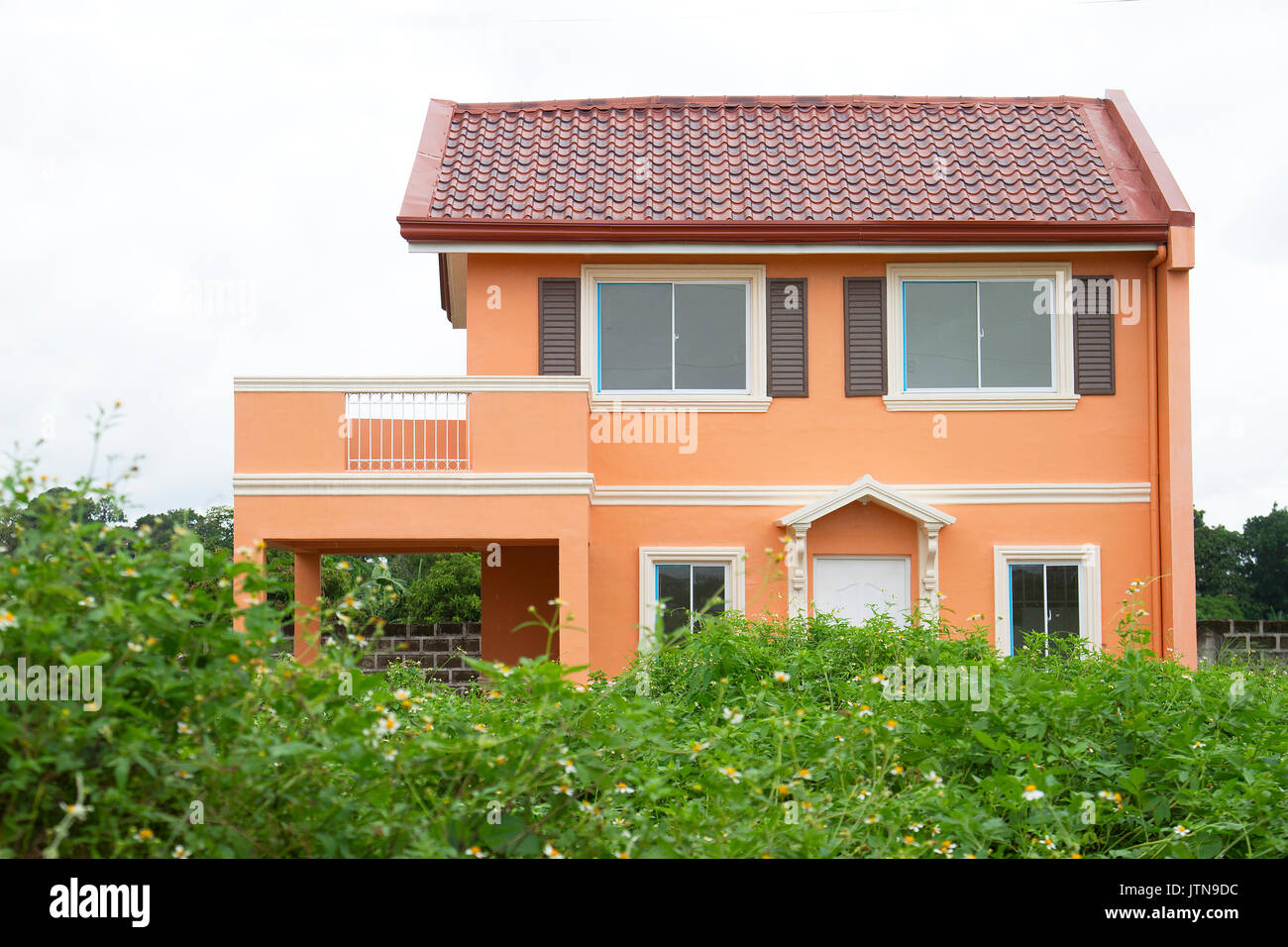 Orange color modern italian house - with grassy foreground Stock Photo
