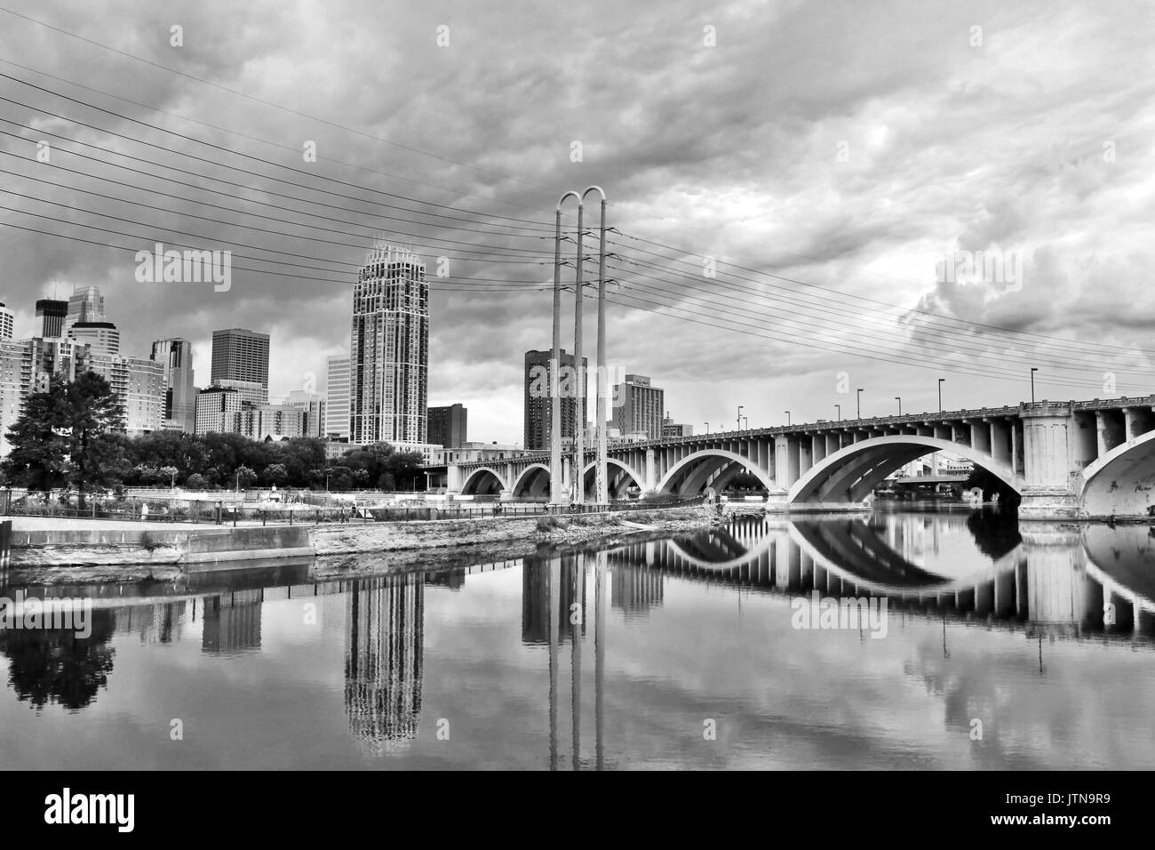 Minneapolis downtown skyline and Third Avenue Bridge above Mississippi river in black and white. Midwest USA, state of  Minnesota. Stock Photo