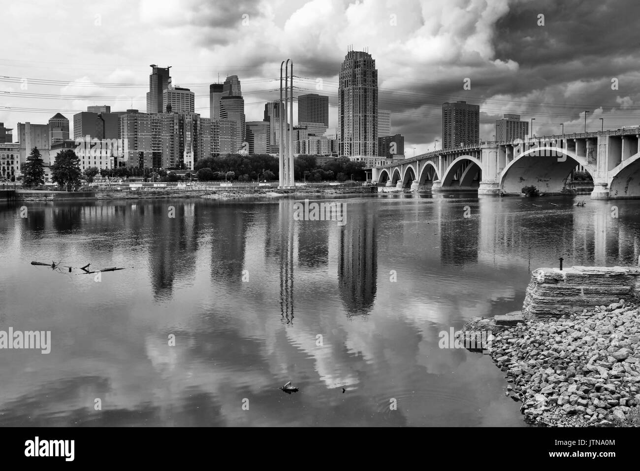 Minneapolis downtown skyline and Third Avenue Bridge above Mississippi river in black and white. Midwest USA, Minnesota state. Stock Photo