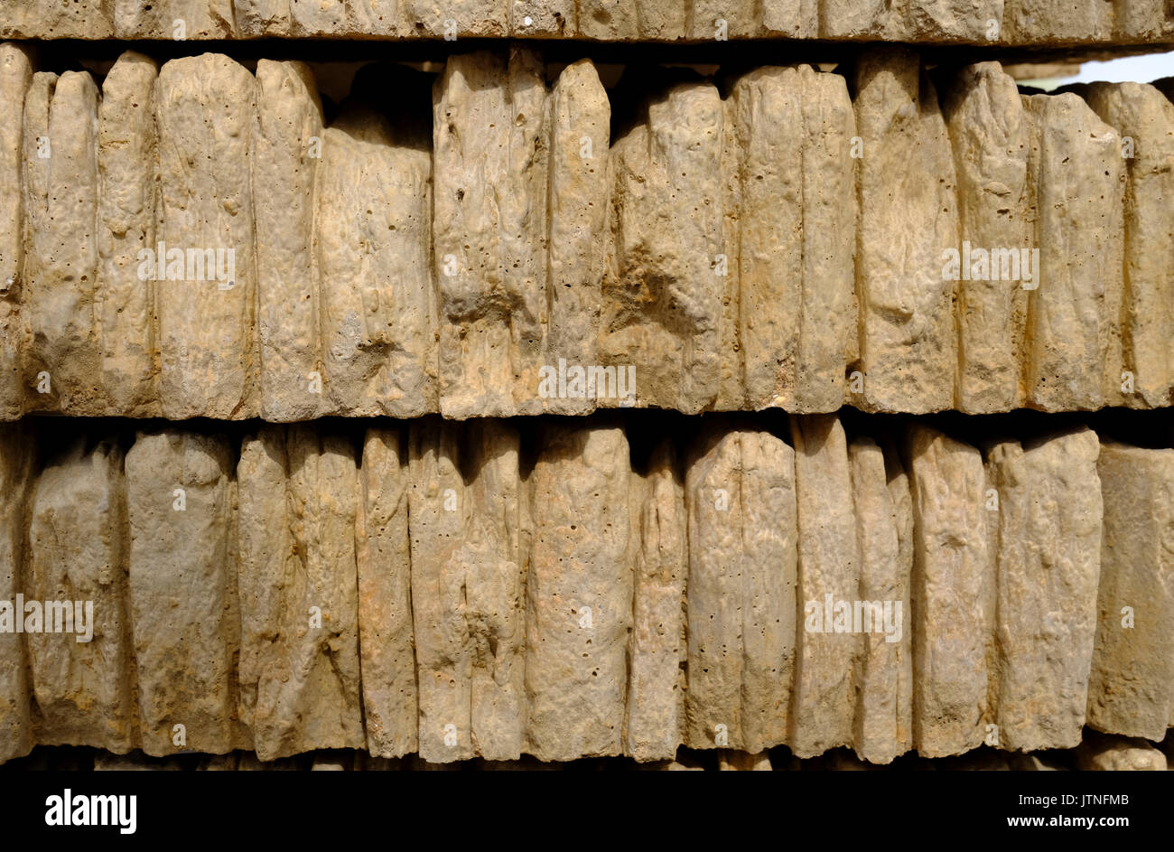 Stacks of gold coloured walling or coping stone for finishing off the top of a wall Stock Photo