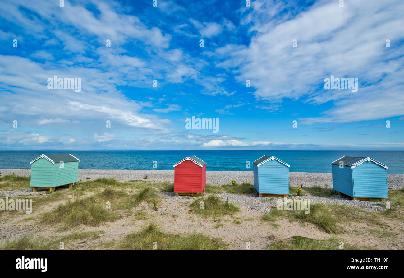 FOUR PASTEL COLOURED BEACH HUTS ON THE SAND AND SHINGLE BEACH FINDHORN MORAY SCOTLAND Stock Photo