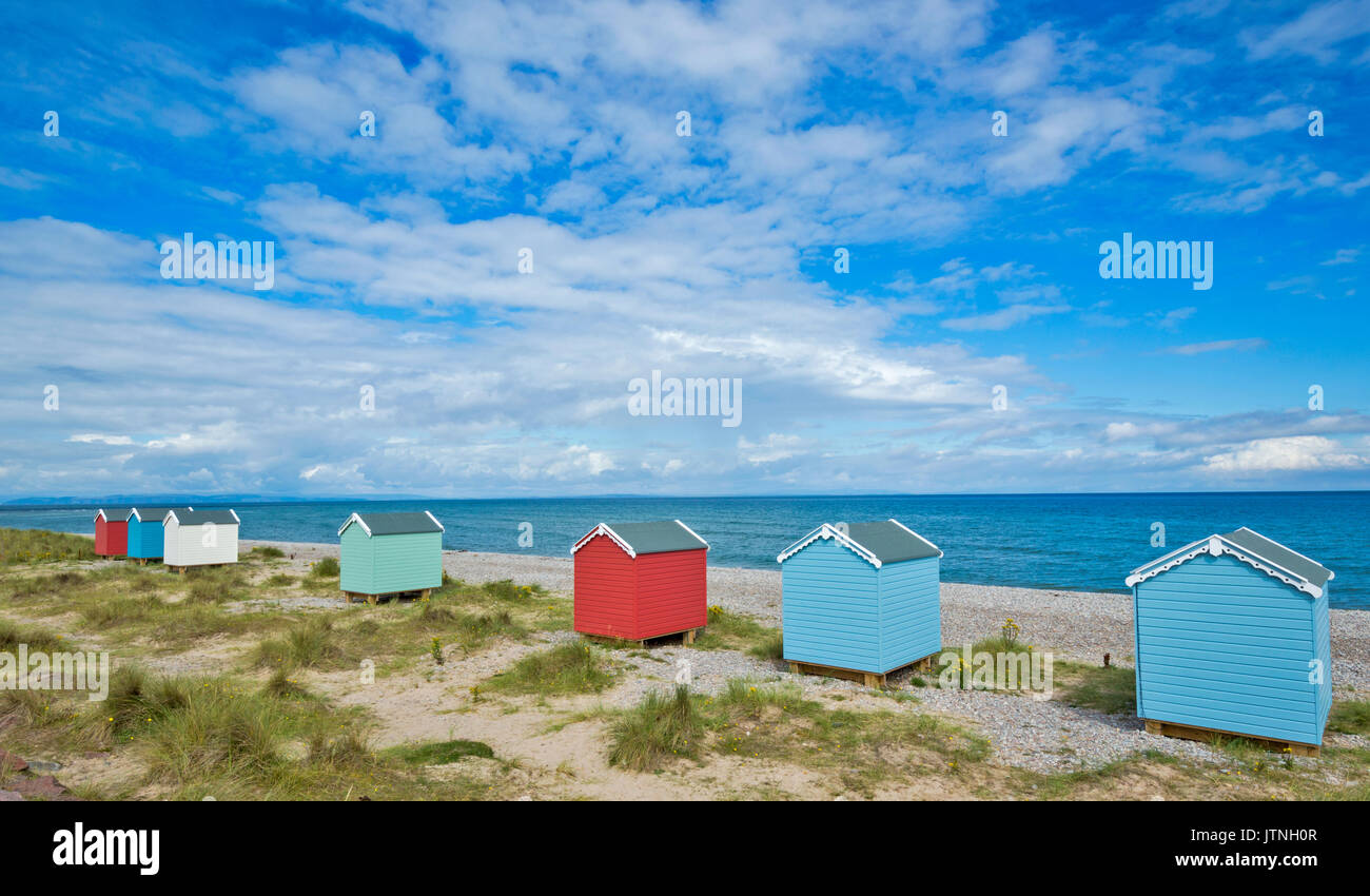 SEVEN PASTEL COLOURED BEACH HUTS ON THE SAND AND SHINGLE BEACH FINDHORN MORAY SCOTLAND Stock Photo