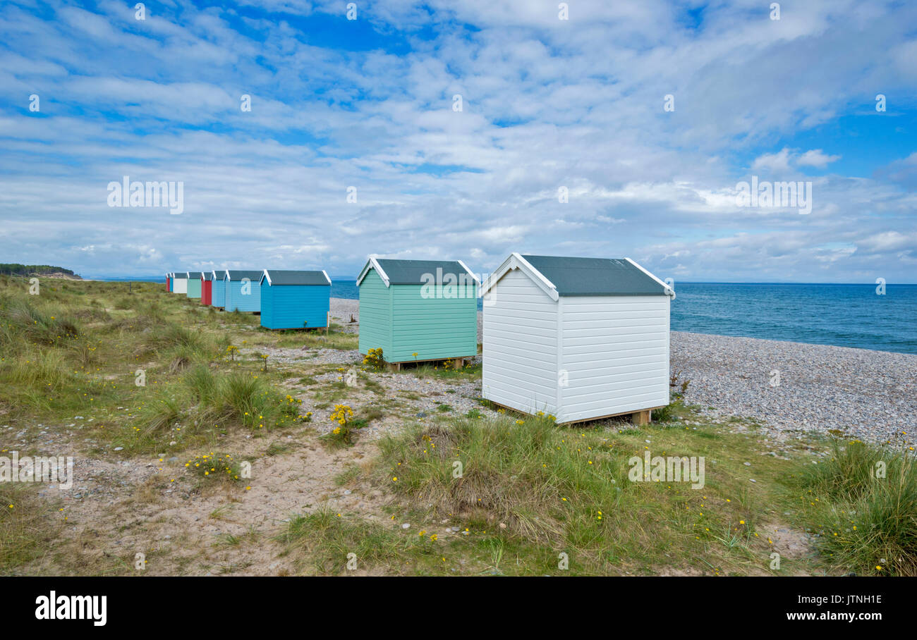 TEN PASTEL COLOURED BEACH HUTS ON THE SAND AND SHINGLE BEACH FINDHORN MORAY SCOTLAND Stock Photo