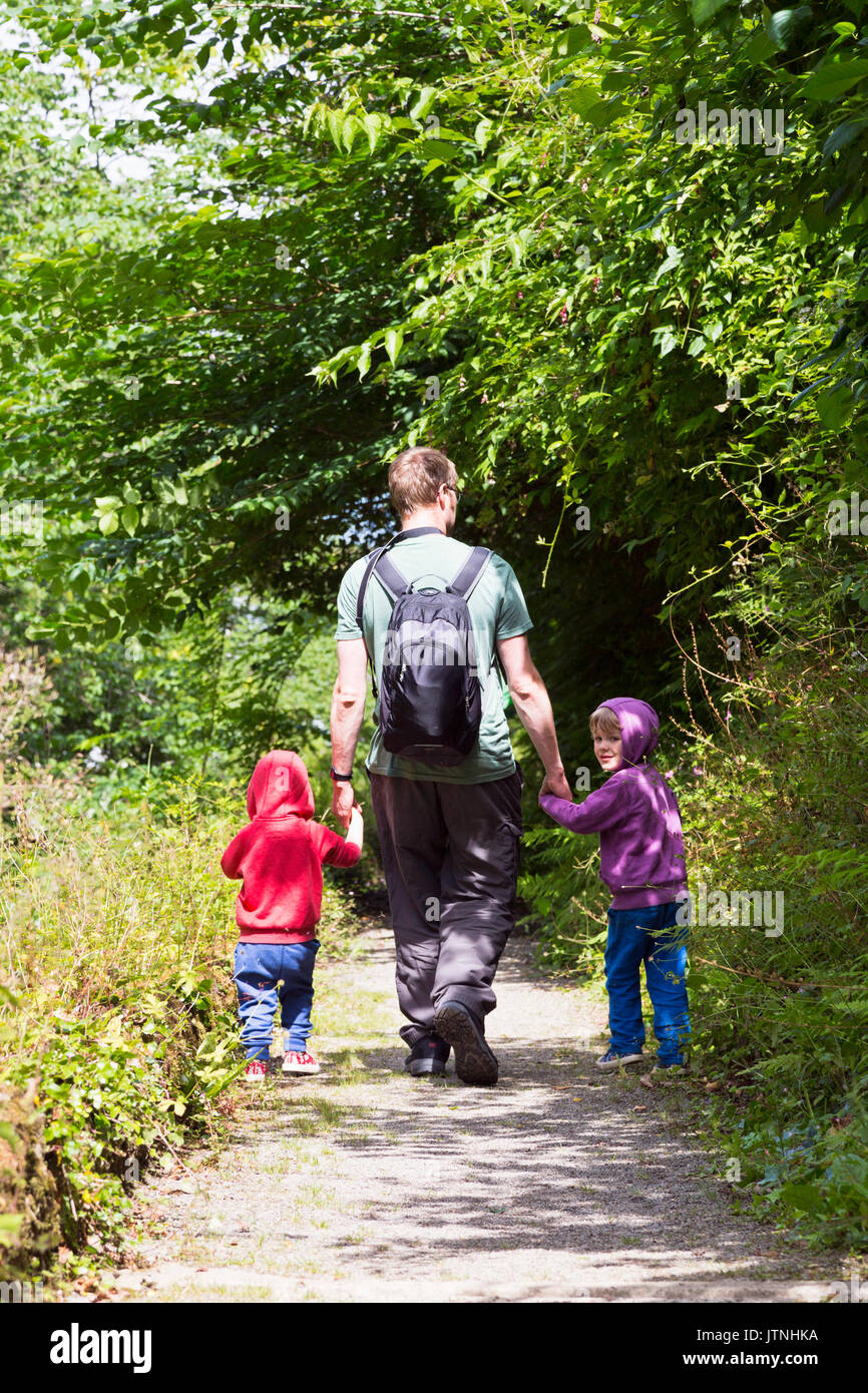 Father and sons walking along a rural path Stock Photo