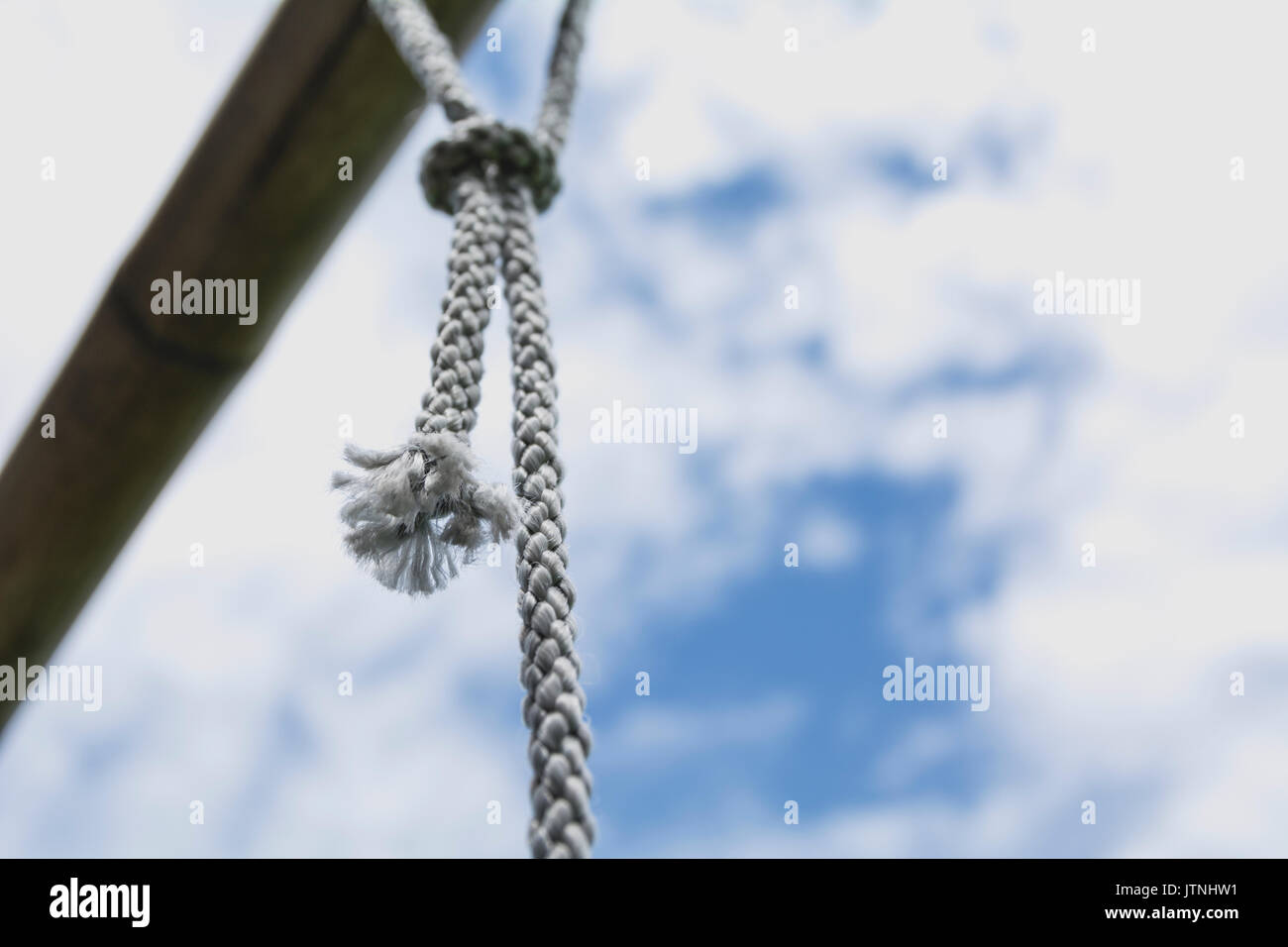 rope knot tied with old rusty steel rod under the sky. Stock Photo