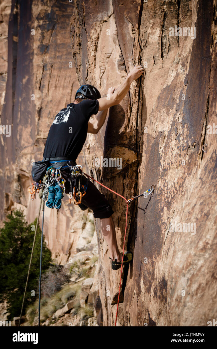 Tyler Price climbs a route in the sandstone of Buckhorn Wash in the San Rafael Swell, Utah. Stock Photo