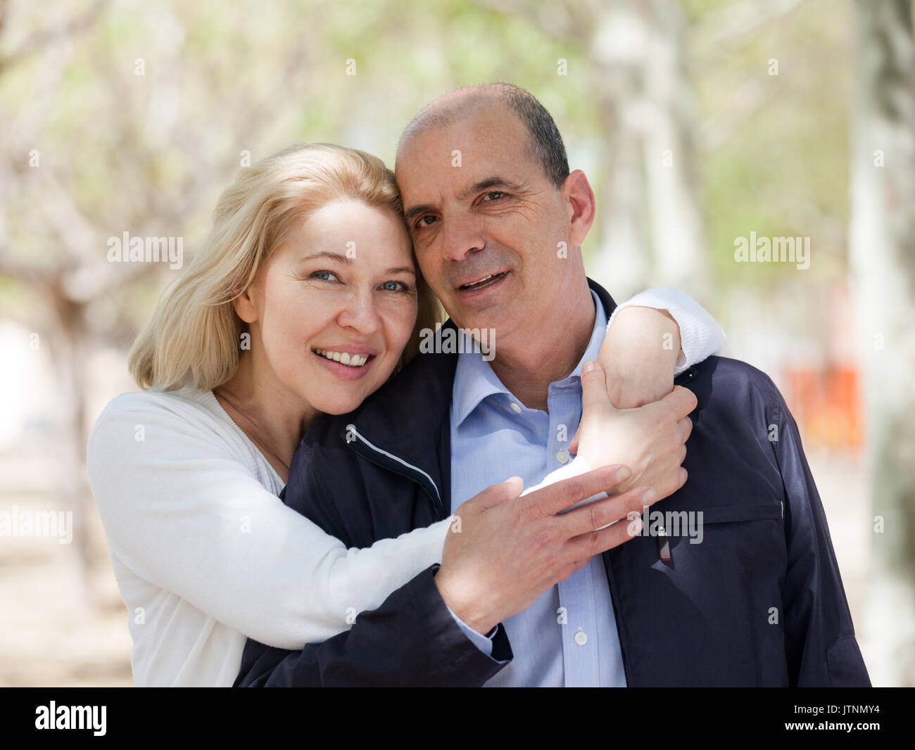 Happy family couple hugging in park and smiling Stock Photo - Alamy