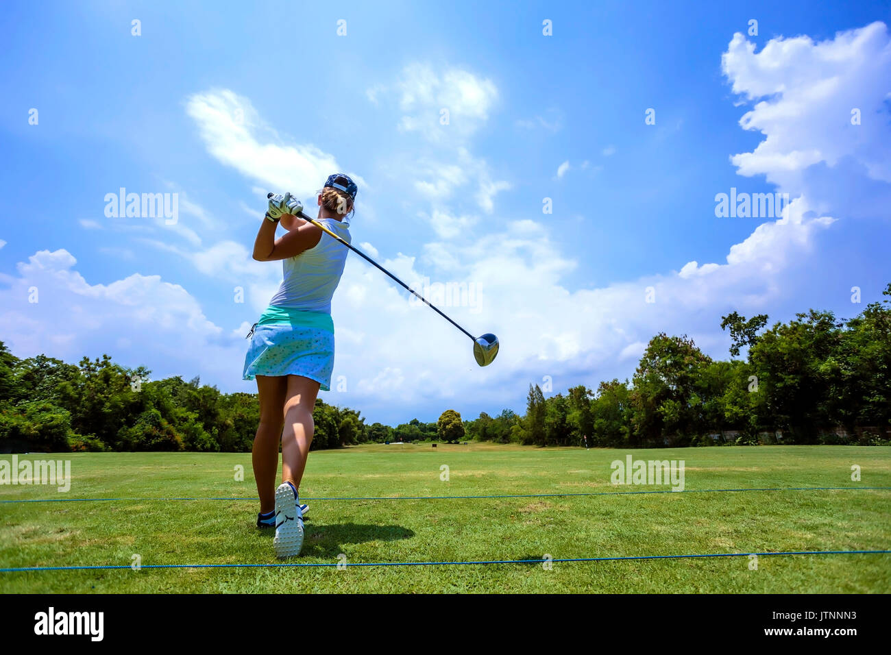 Young woman playing golf, Bali, Indonesia Stock Photo