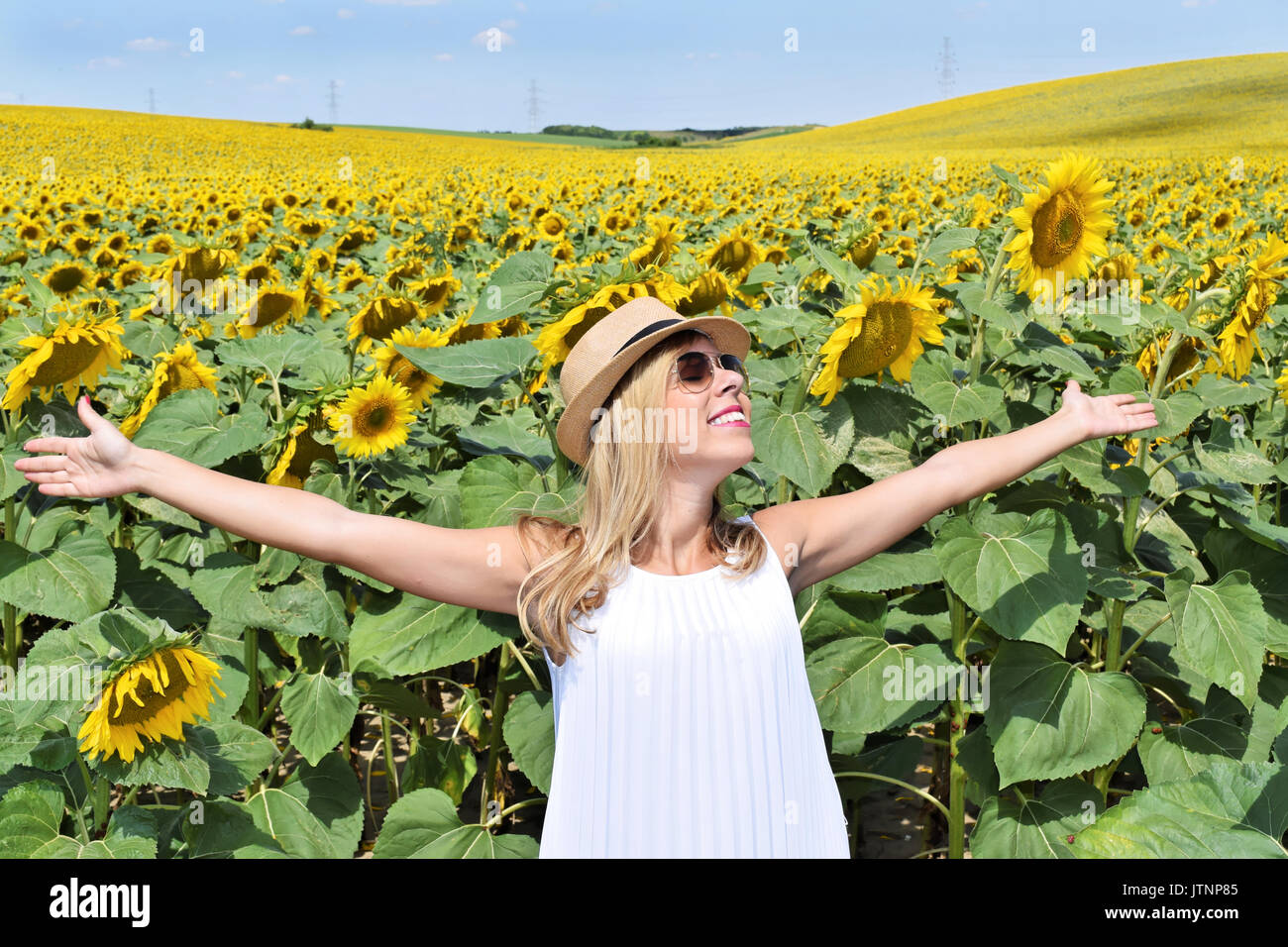 Cheerful girl in a sunflower farm enjoying the sun Stock Photo - Alamy