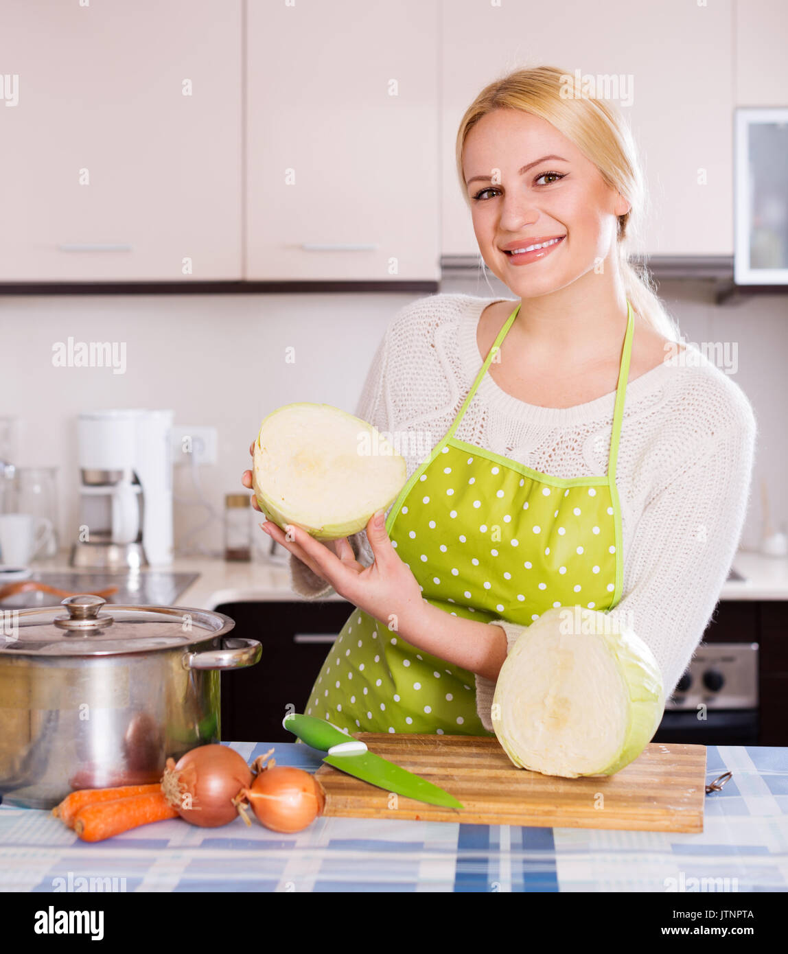 Happy blonde in apron holding cabbage at kitchen Stock Photo - Alamy