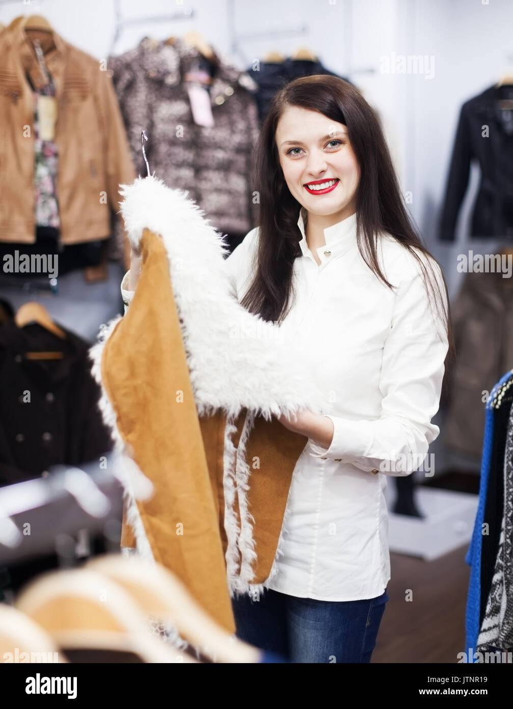 Ordinary woman choosing jacket at fashion boutique Stock Photo - Alamy