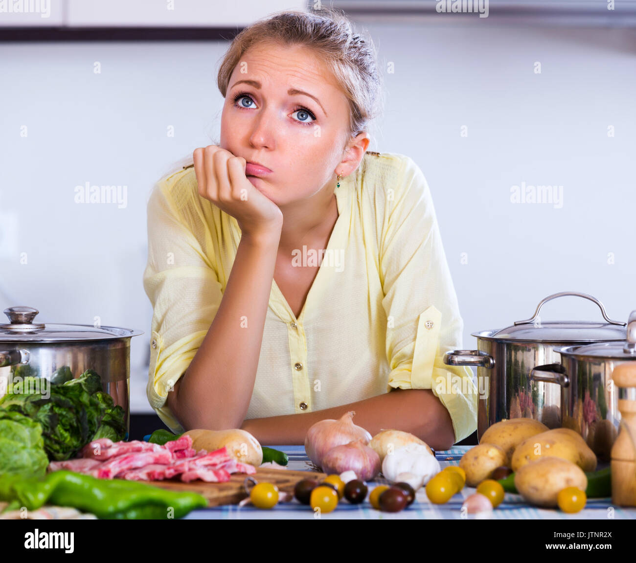Frustrated girl looking at dinner ingredients with sad face Stock ...