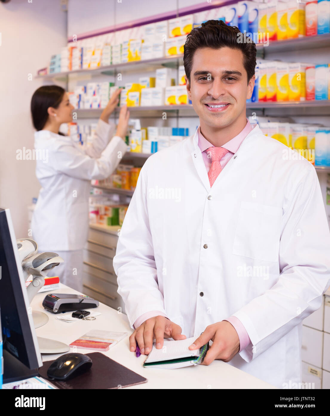 Farmacist Portrait of positive pharmacist and assistant working at farmacy ...