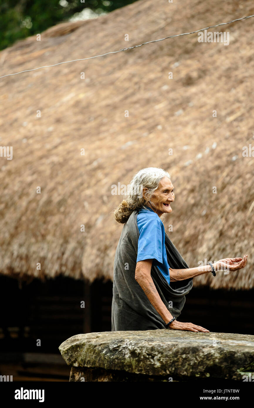 Portrait of smiling senior woman against traditional house, Sumba, Indonesia Stock Photo
