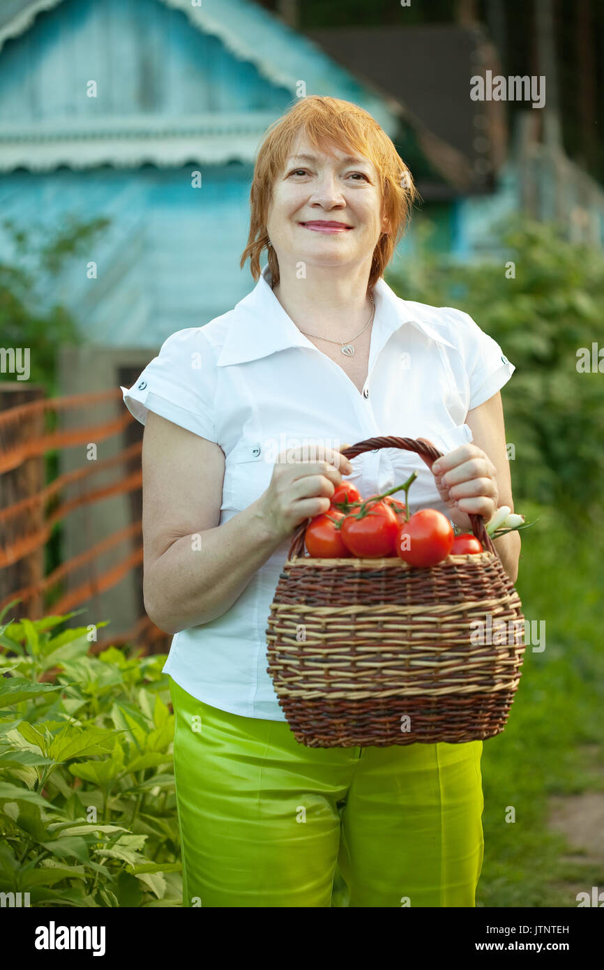 Happy mature woman with basket of harvested vegetables Stock Photo - Alamy