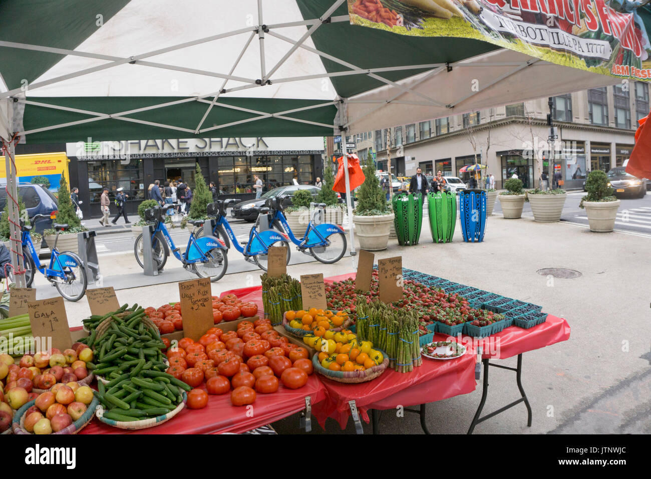 farmers market with luscious spring produce shares partly closed section Broadway between 36th & 35th street with Citibike station & 3 recycling cans Stock Photo