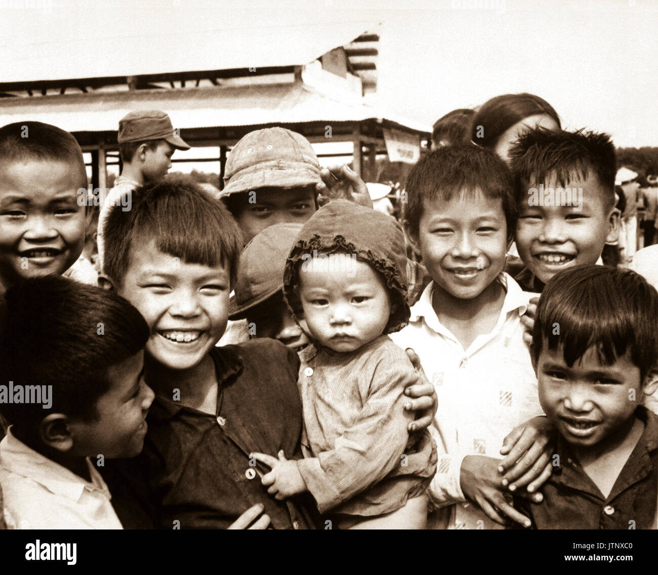 A new market for 'Tinh Thuong.'  Children gather before the market which was built with assistance from the government of Vietnam and USAID.  (USIA) EXACT DATE SHOT UNKNOWN NARA FILE #:  306-MVP-6-9 WAR & CONFLICT BOOK #:  409 Stock Photo
