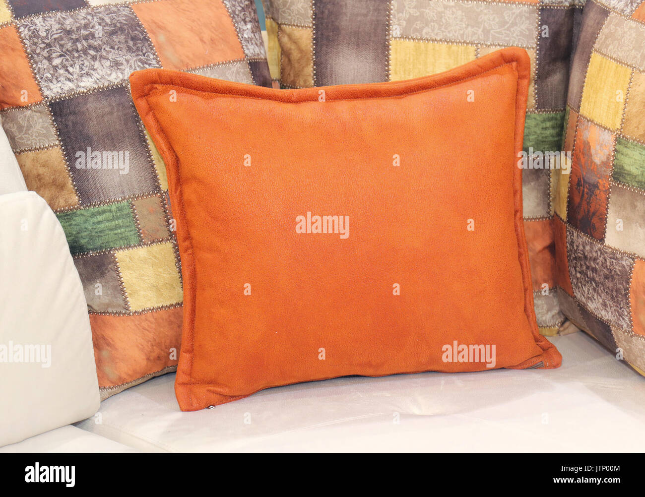 Soft Orange Decorative Pillow With More Pillows In The Back Stock