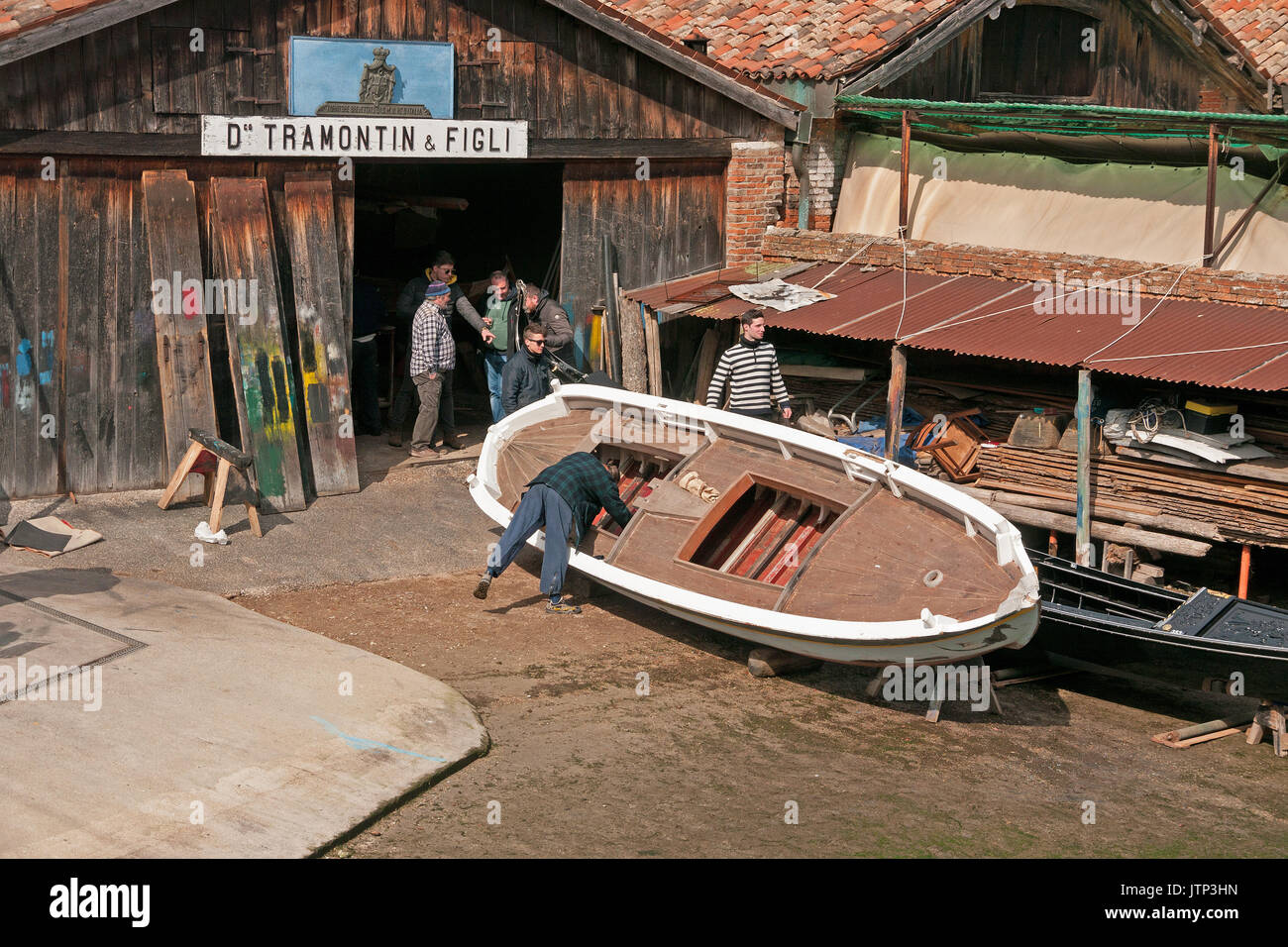 Men working on the boat building of Gondolas in a canal workshop and boat builders Stock Photo