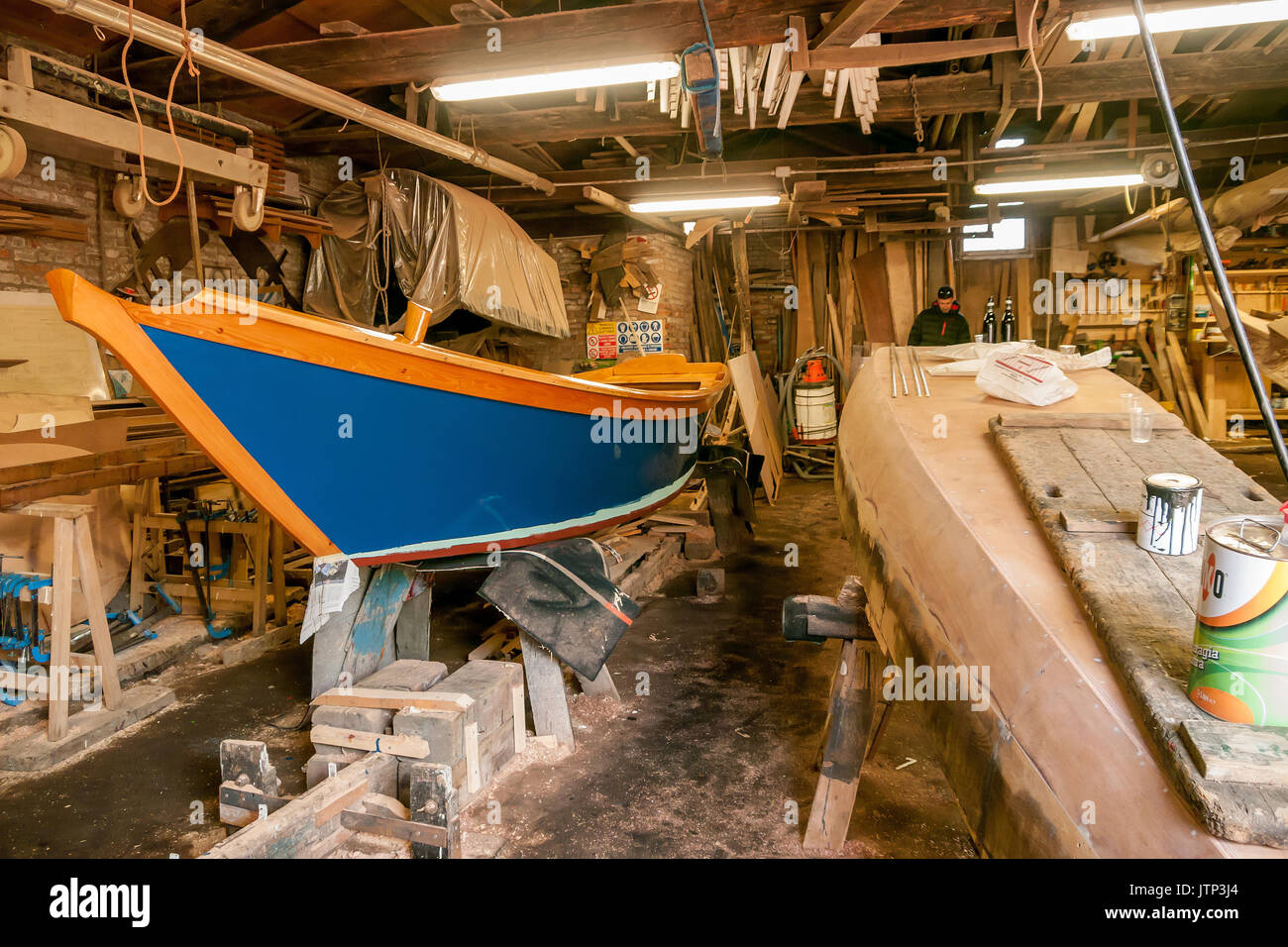 Man working on the boat building of Gondolas in a canal workshop and boat builders Stock Photo