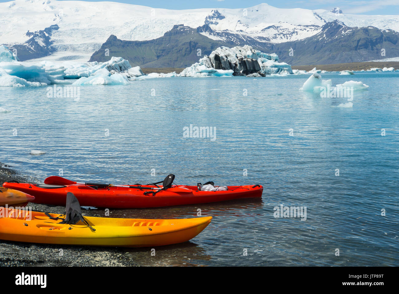 Iceland - Canoes in water at black sand beach of glacial lake Stock Photo