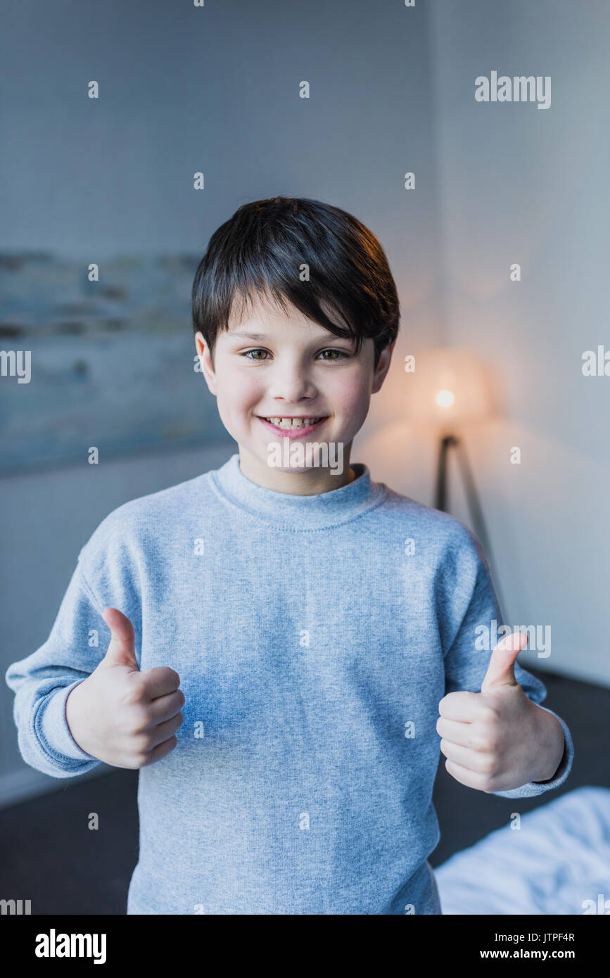 Cute little boy showing thumbs up and smiling at camera Stock Photo - Alamy