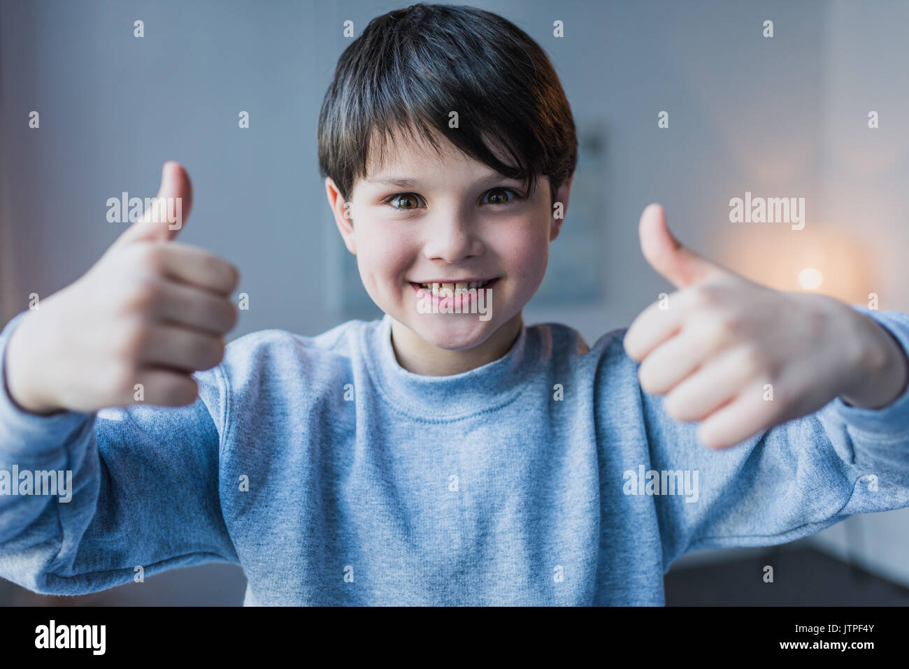 Cute little boy showing thumbs up and smiling at camera Stock Photo - Alamy