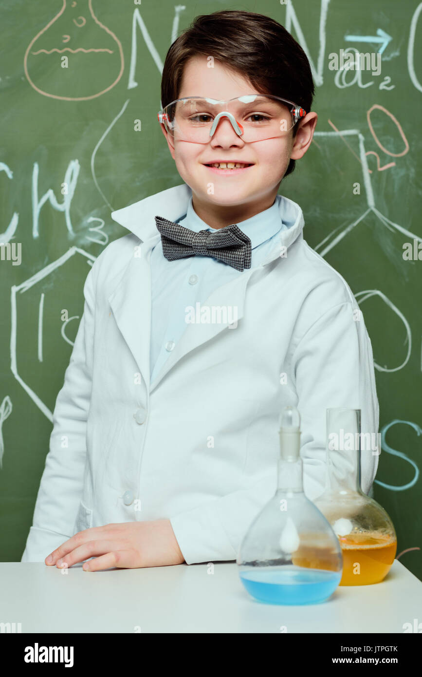 portrait of little boy in lab coat and protective glasses with