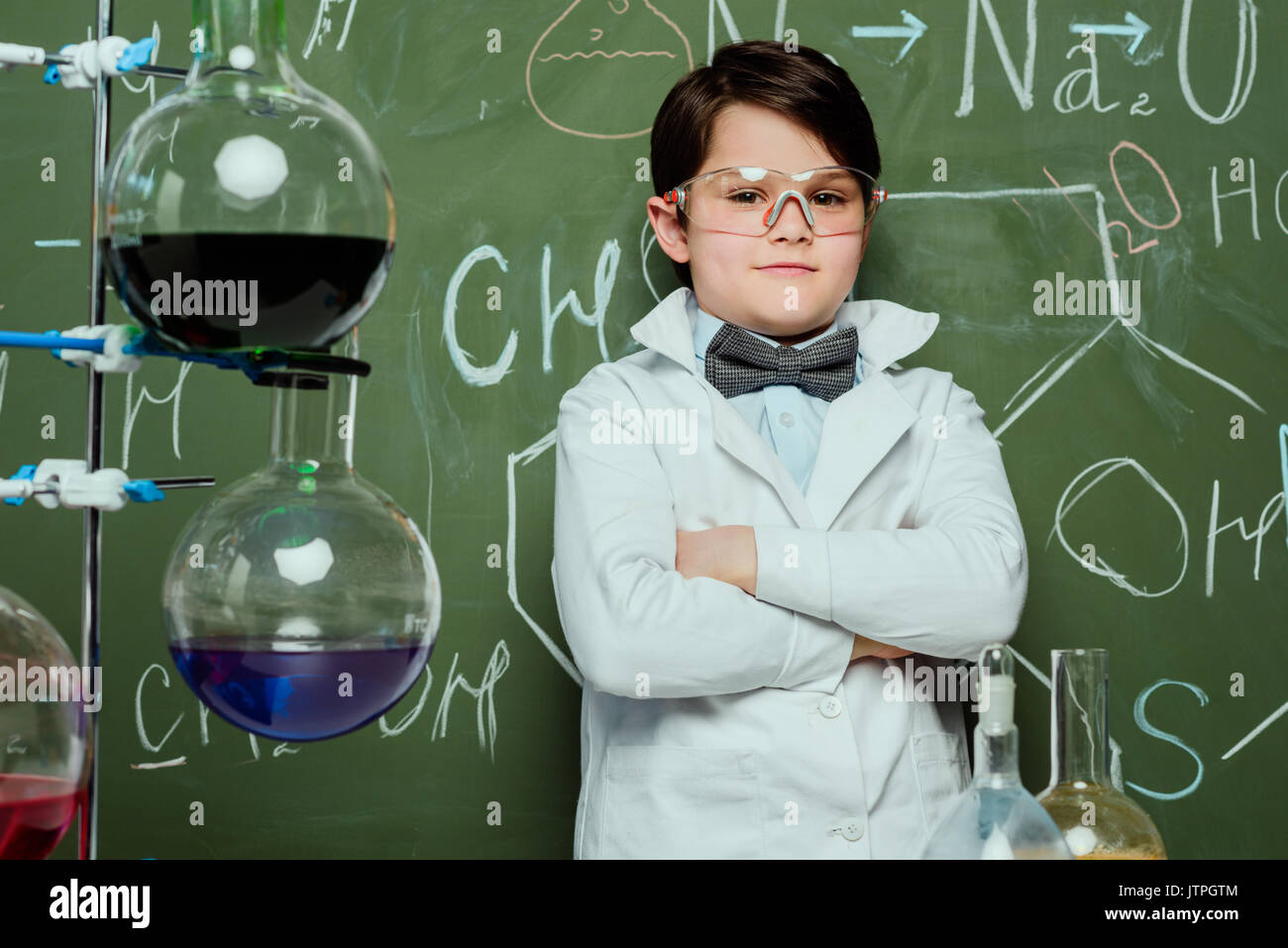 portrait of little boy in lab coat and protective glasses with