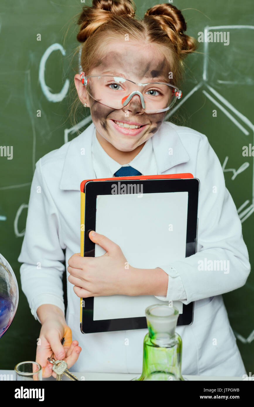 portrait of little girl in lab coat holding digital tablet in science