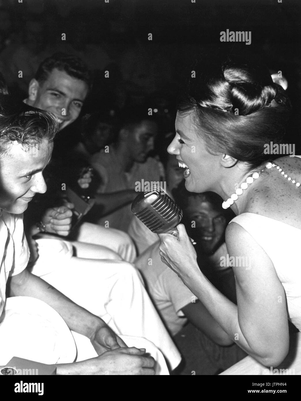 Twenty-one year old James R. Gould is the envy of 3,000 crewmemberrs as television actress Kathleen Nolan singles him out for a song.  The young sailor and Bon Homme Richard both celebrated their 'coming of age' on November 26, 1965. (USIA) NARA FILE #:  306-MVP-8-6 WAR & CONFLICT BOOK #:  392 Stock Photo