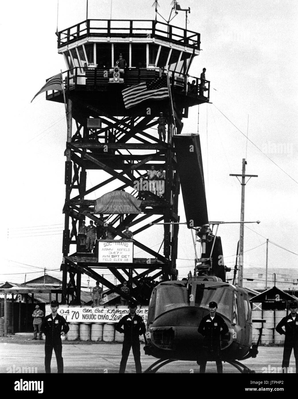 Moments before the U.S. flag was replaced by the Vietnamese flag, Vietnamese Air Force crewmen line up before one of the 62 UH-1 'Huey' helicopters turned over to them November 4, 1970, along with command of the Soc Trang airfield.  (USIA) EXACT DATE SHOT UNKNOWN NARA FILE #:  306-MVP-14-31 WAR & CONFLICT BOOK #:  401 Stock Photo
