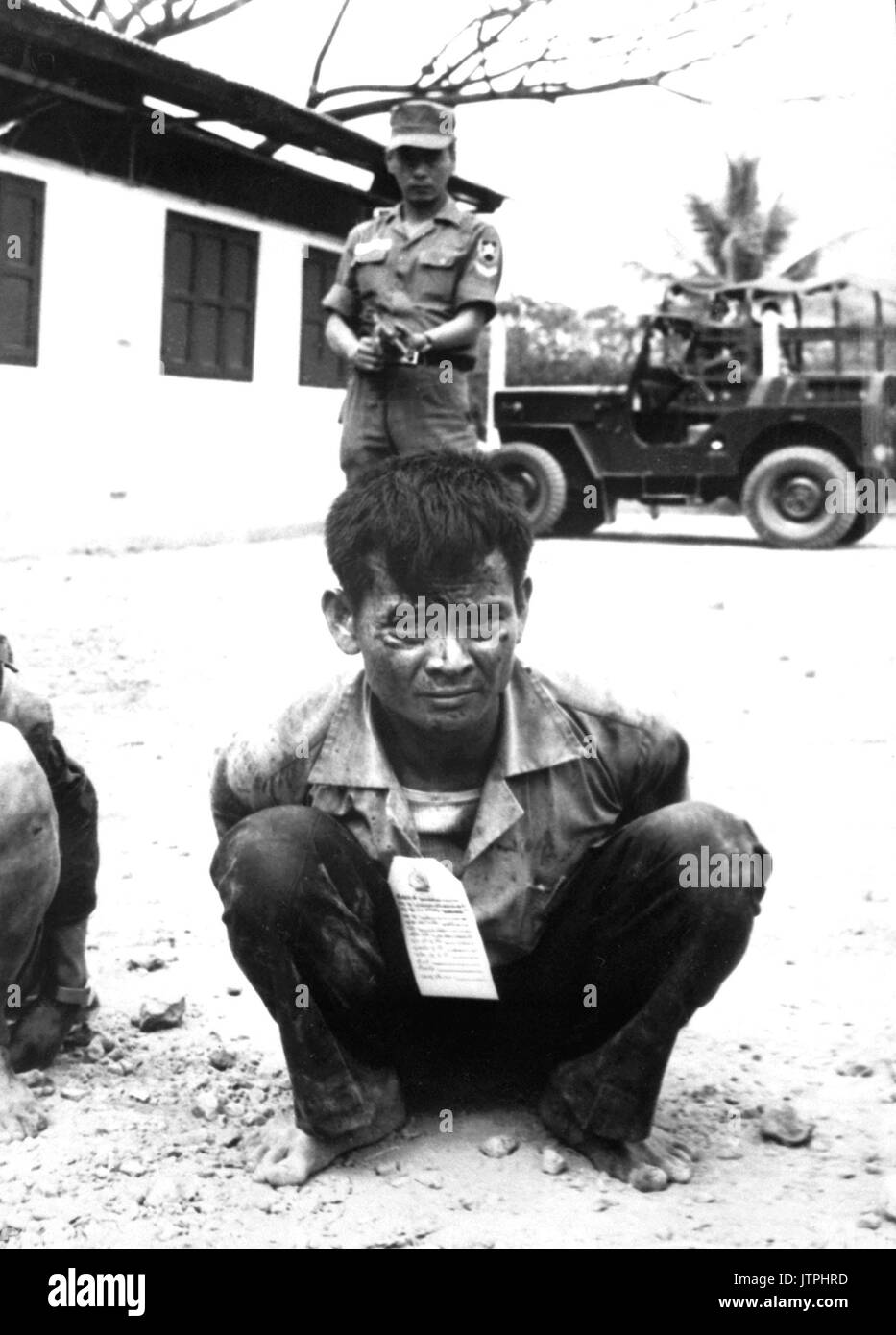 Youthful hard-core Viet Cong, heavily guarded, awaits interrogation following capture in the attacks on the capital city during the festive Tet holiday period.  1968.  (USIA) EXACT DATE SHOT UNKNOWN NARA FILE #:  306-MVP-21-1 WAR & CONFLICT BOOK #:  414 Stock Photo