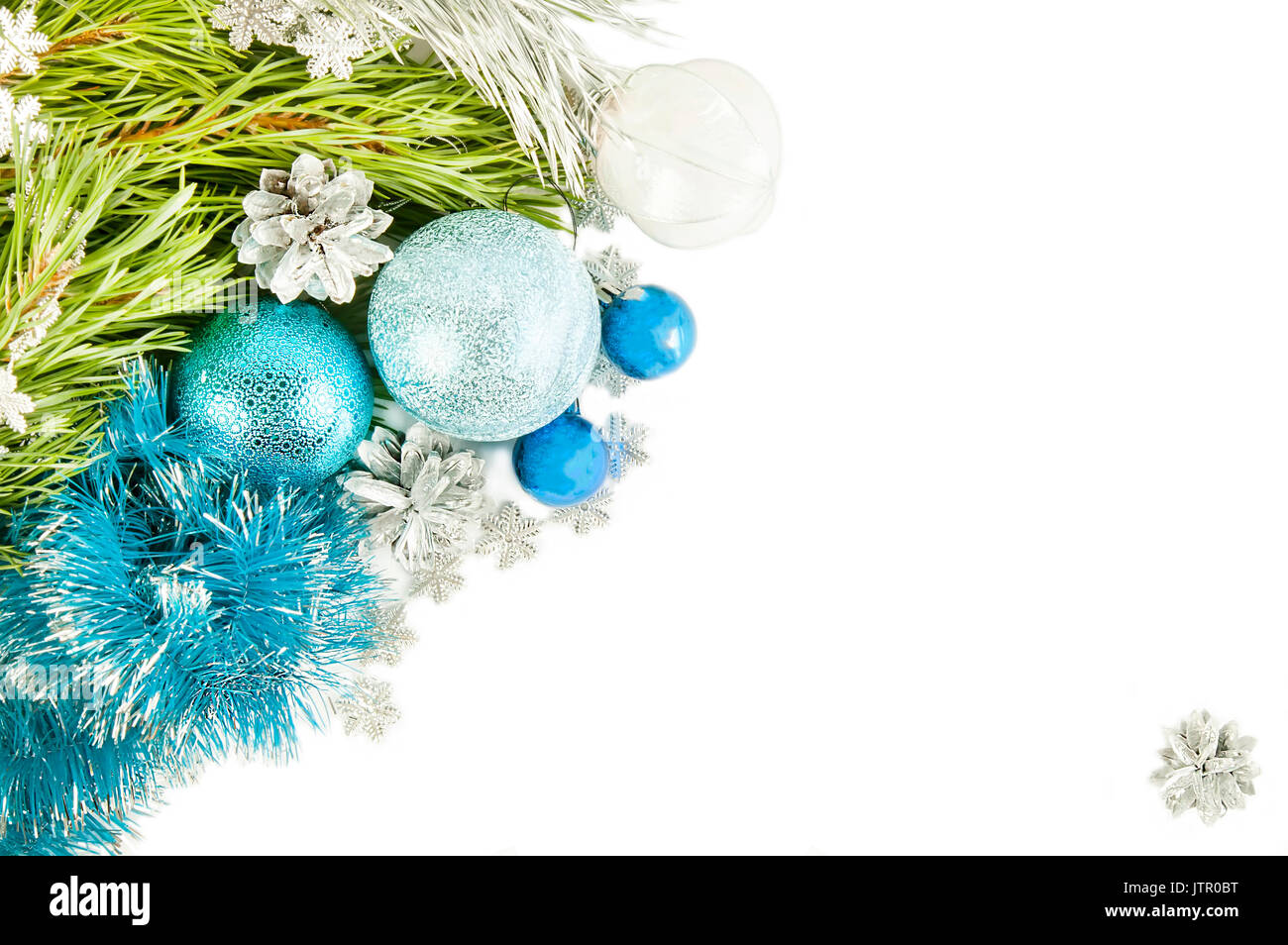 Fir tree branch and cones with blue balls and tinsel isolated on white ...