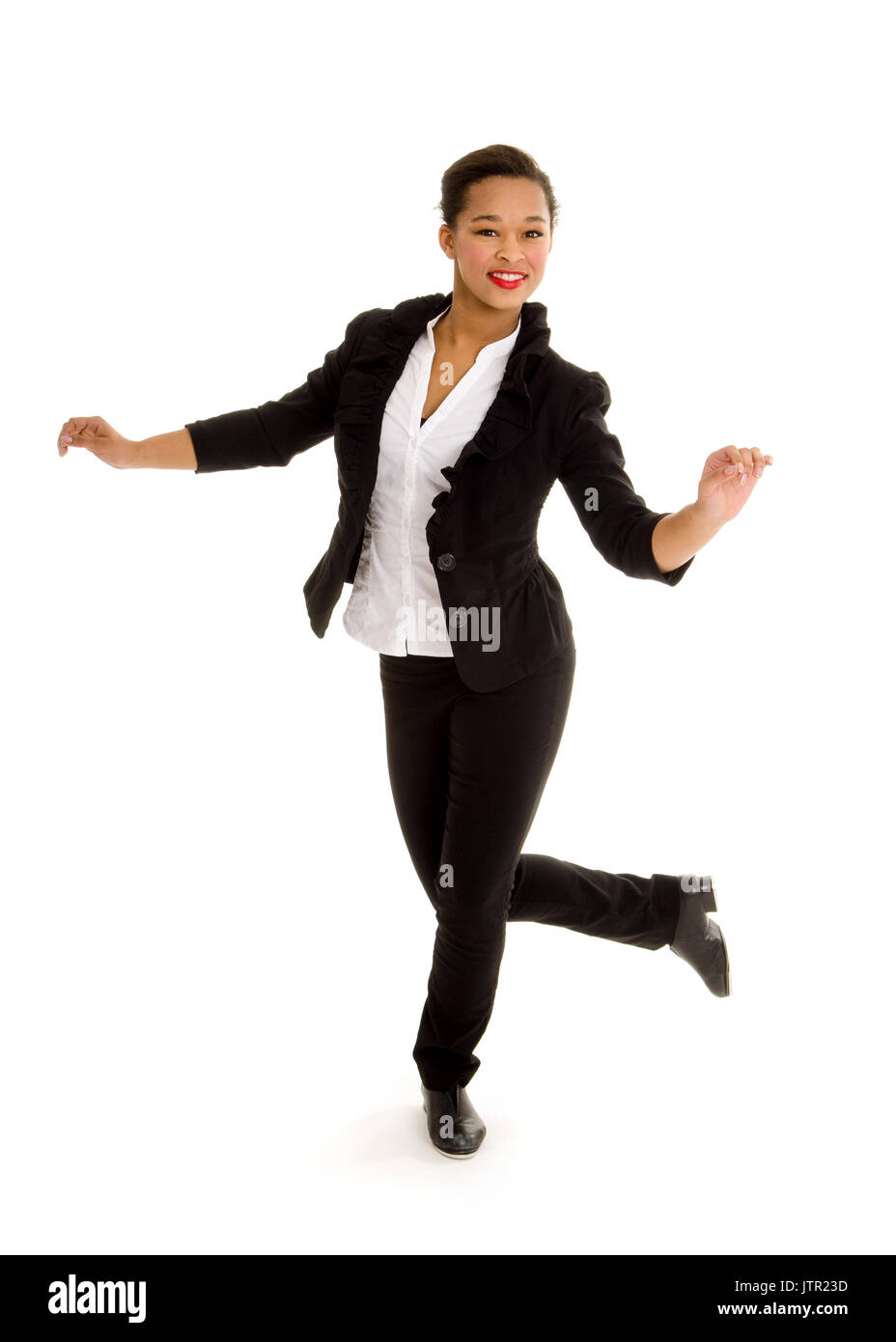 A Smiling Tap Dancing Girl in Black Costume Performs a Dance Routine Stock Photo