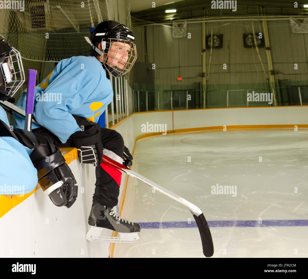 A Hockey Player on the Bench at the Rink is Ready to Jump on the Ice and Play Stock Photo