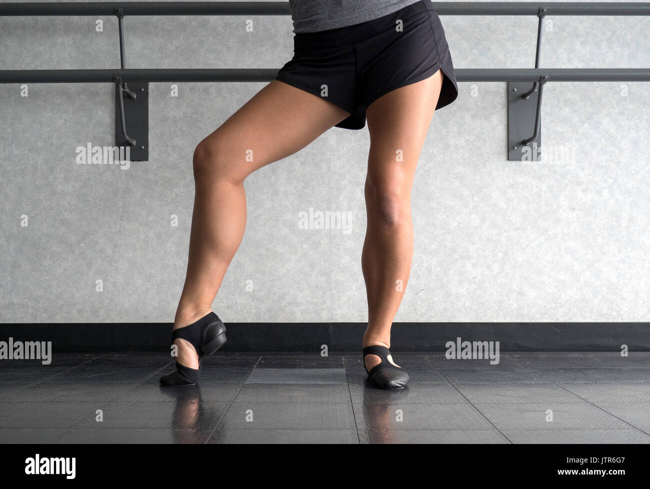 Posing in Jazz shoes at the barre in dance class Stock Photo