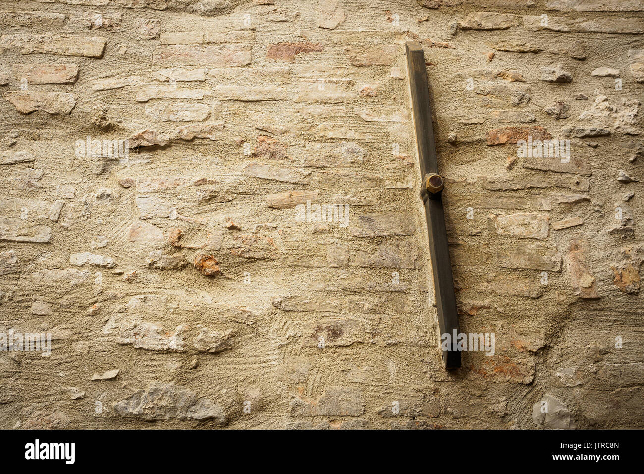 Old metal rod anchor bar on a brick and stone masonry wall. Stock Photo