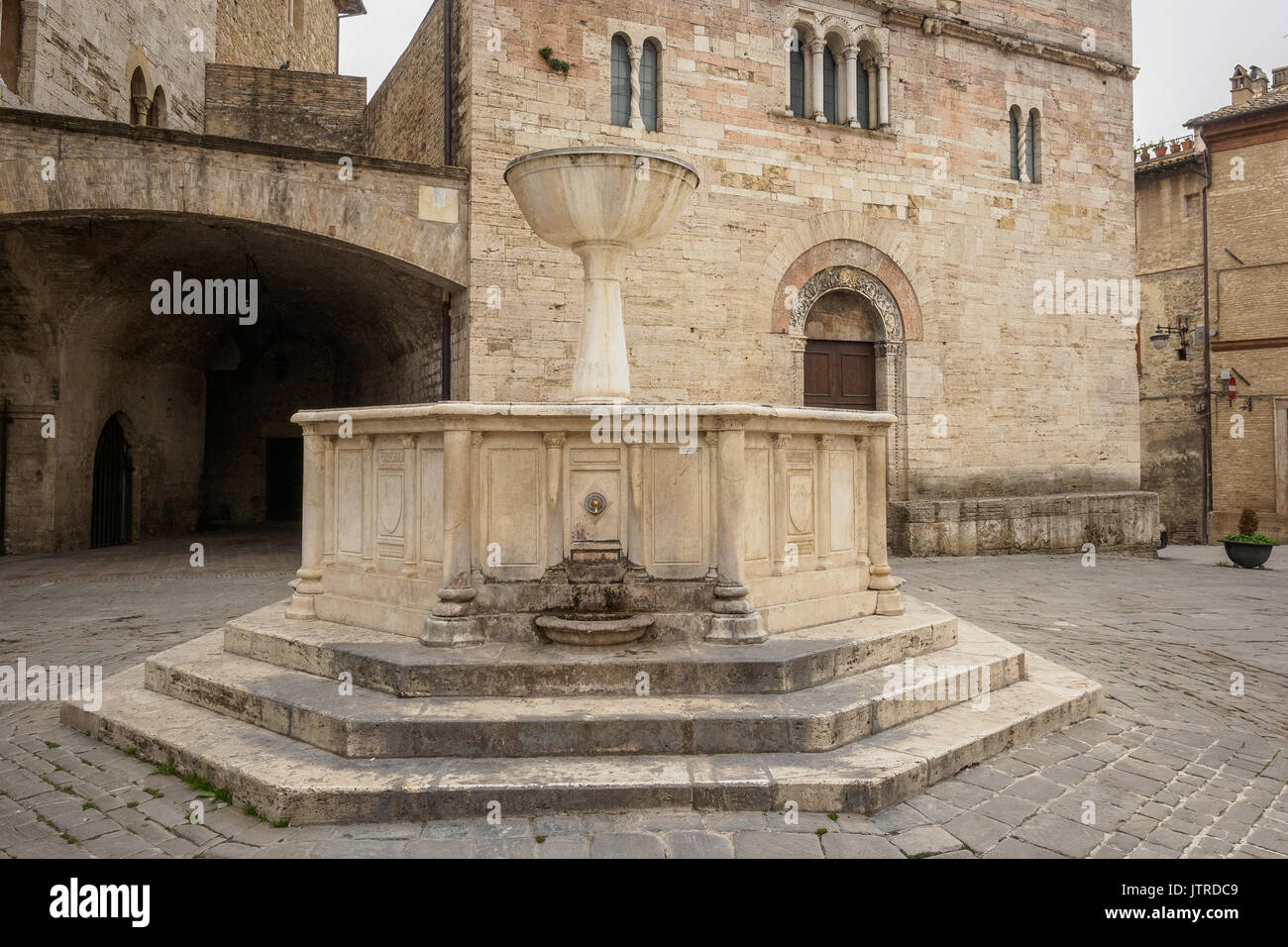 Medieval fountain and San Silvestro Church façade in the main square of the town of Bevagna in Umbria (Italy). Stock Photo