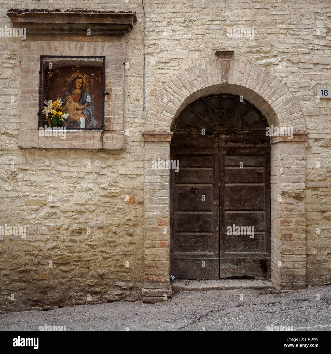 Wall painting ('edicola sacra' in the Italian language) of the Holy Virgin on a building wall in an alley of Bevagna (Italy). March 2017. Stock Photo
