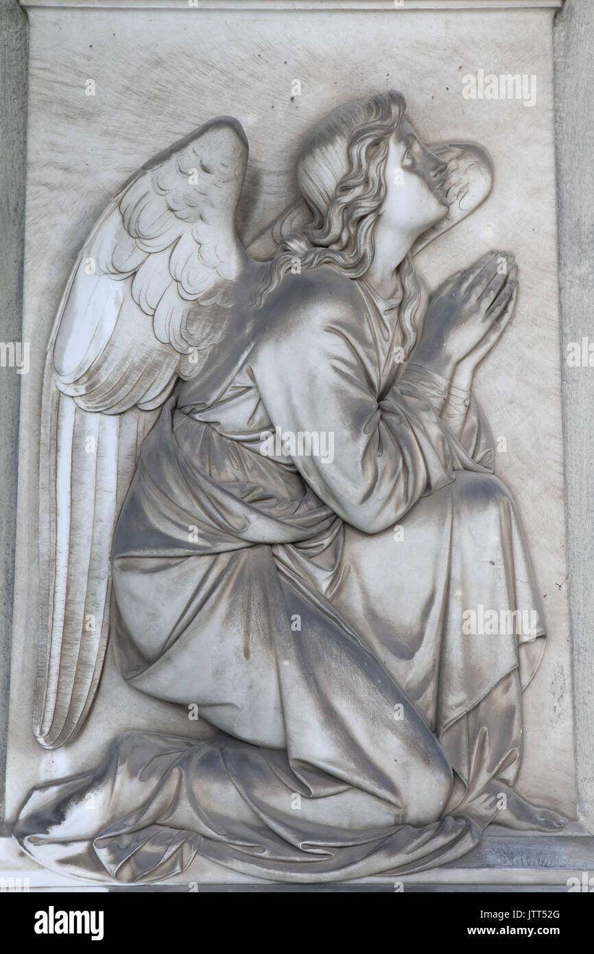 Praying angel depicted on one of the marble funeral monuments at the Staglieno Monumental Cemetery (Cimitero monumentale di Staglieno) in Genoa, Liguria, Italy. Stock Photo