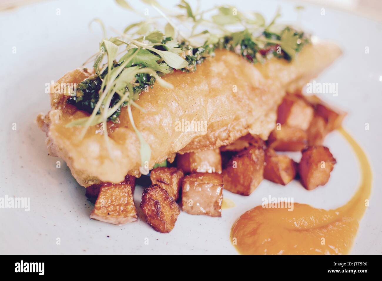 Gourmet battered fish with fried sweet potatoes Stock Photo