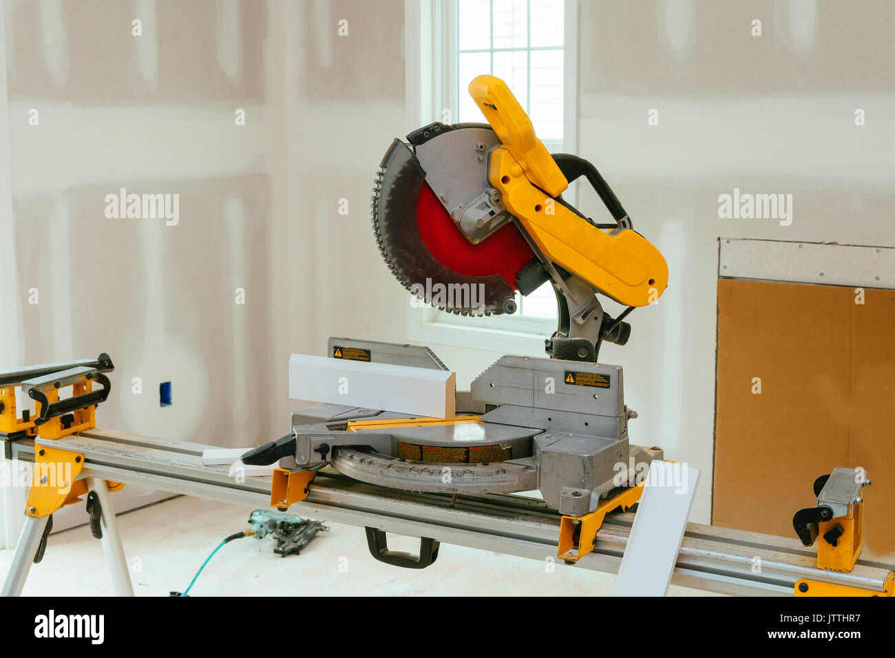 Carpenter cutting wooden plank with circular saw wearing safety