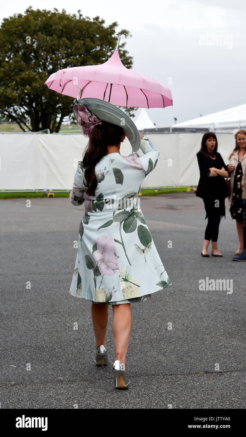 Brighton, UK. 10th Aug, 2017. Maria Cheslinin arrives under her pink parasol on a bright but breezy day for Brighton Races Route Mobile Ladies Day during the three day Maronthonbet Festival of Racing Credit: Simon Dack/Alamy Live News Stock Photo