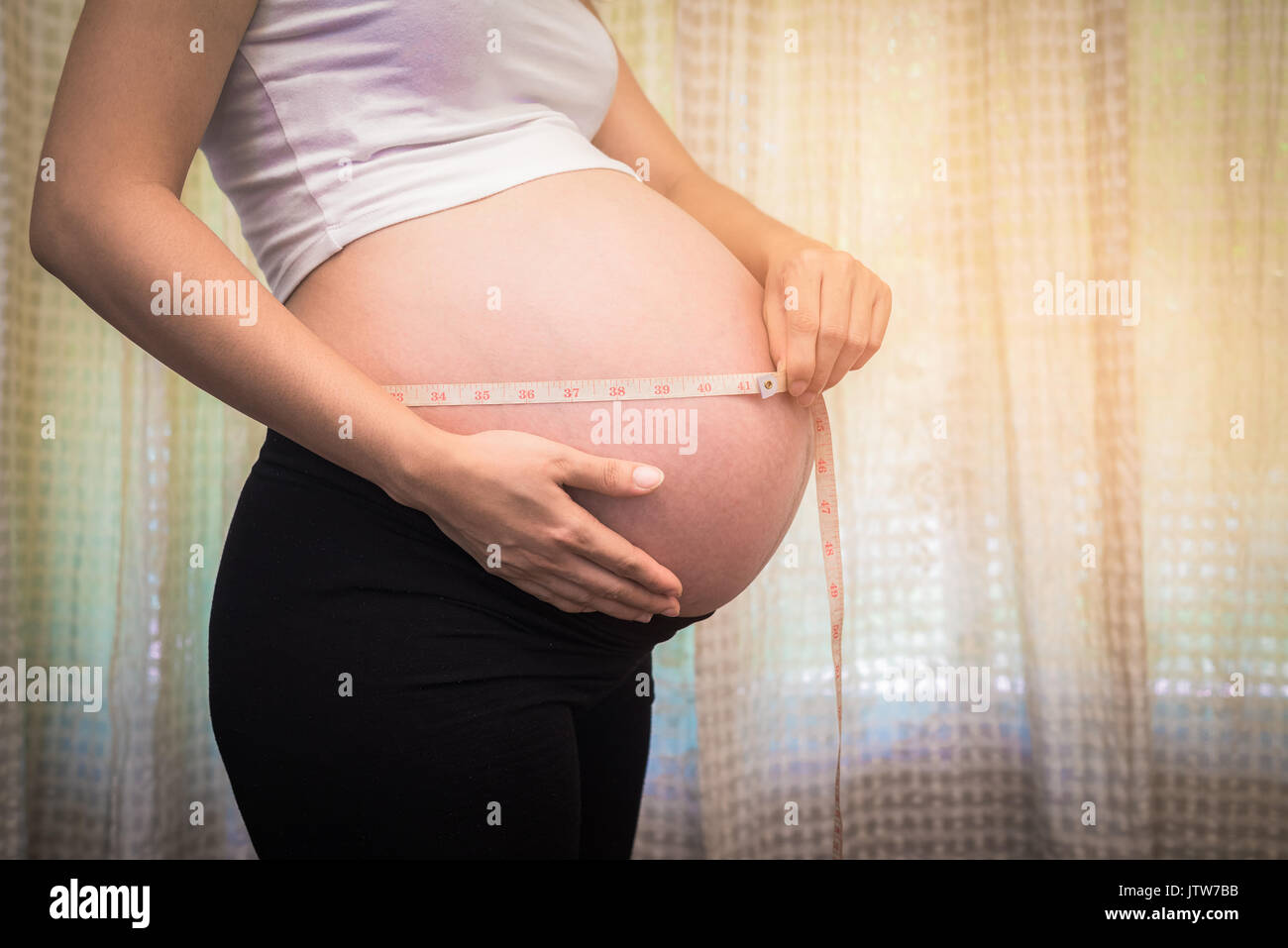 a pregnant woman measure Belly, baby coming soon on the world Stock Photo