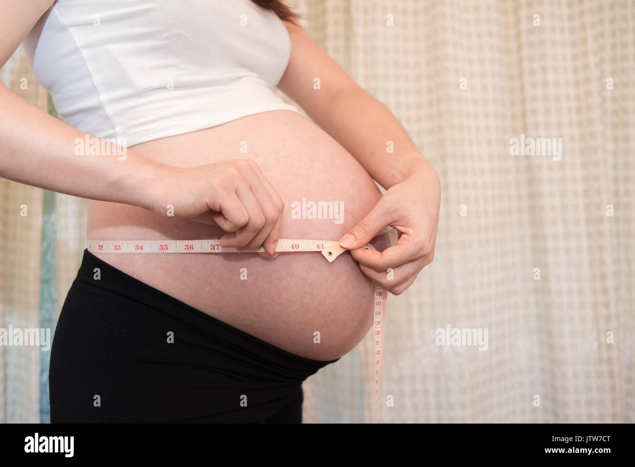 a pregnant woman measure Belly, baby coming soon on the world Stock Photo